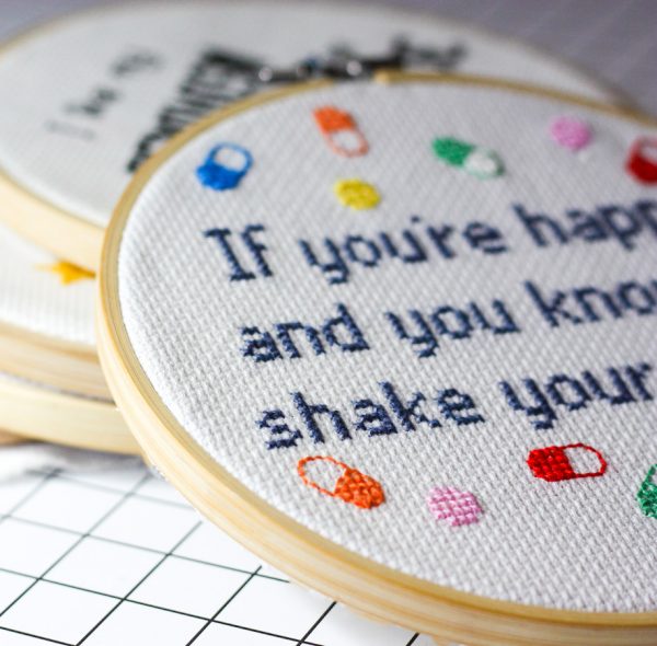 a group of embroidery hoops with words and a couple of small objects
